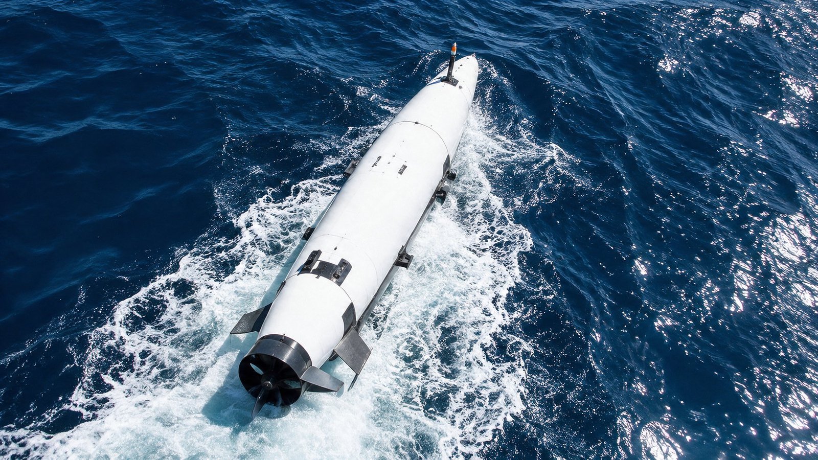 The extra-large unmanned underwater vehicle running on the surface in open ocean, seen from above.
